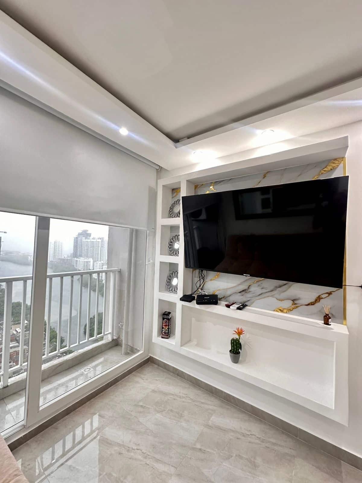 Sala moderna con televisor y vista panorámica de la ciudad desde apartamento en Cartagena
