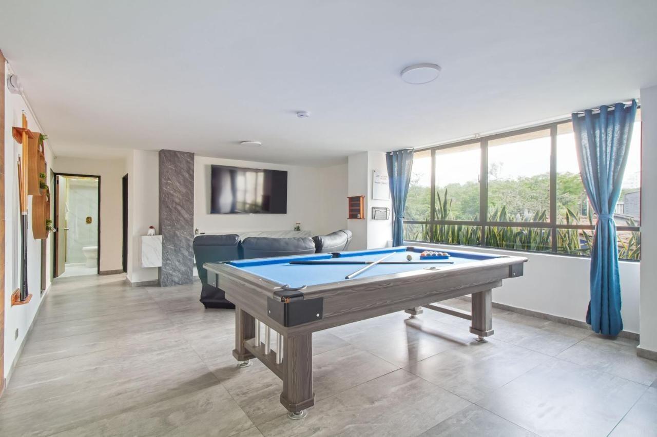 Zona social moderna con mesa de billar y televisor en apartamento cerca de Lleras en Medellín