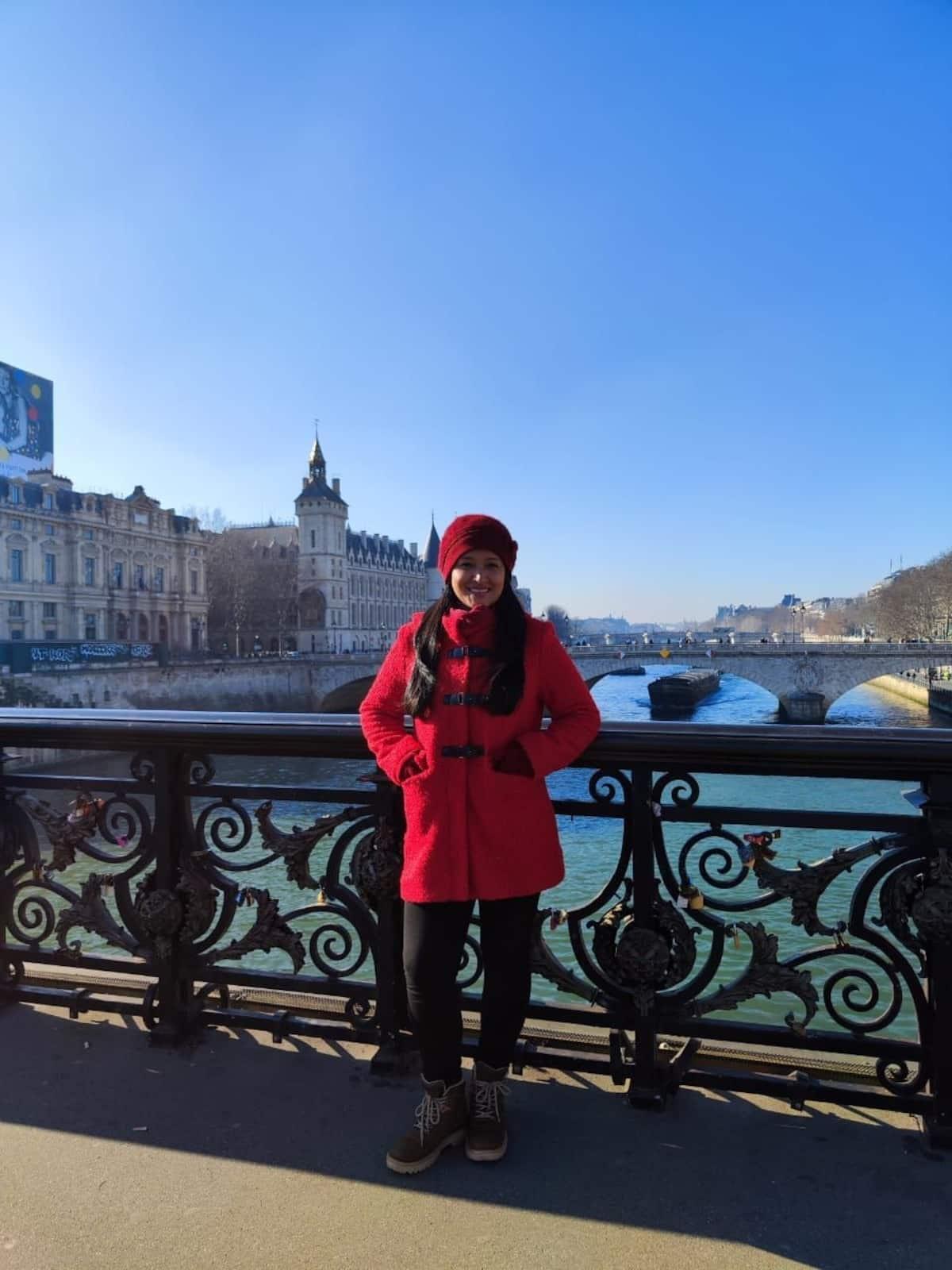 Turista en puente parisino con vista a río, cerca de apartamento vacacional Montenegro