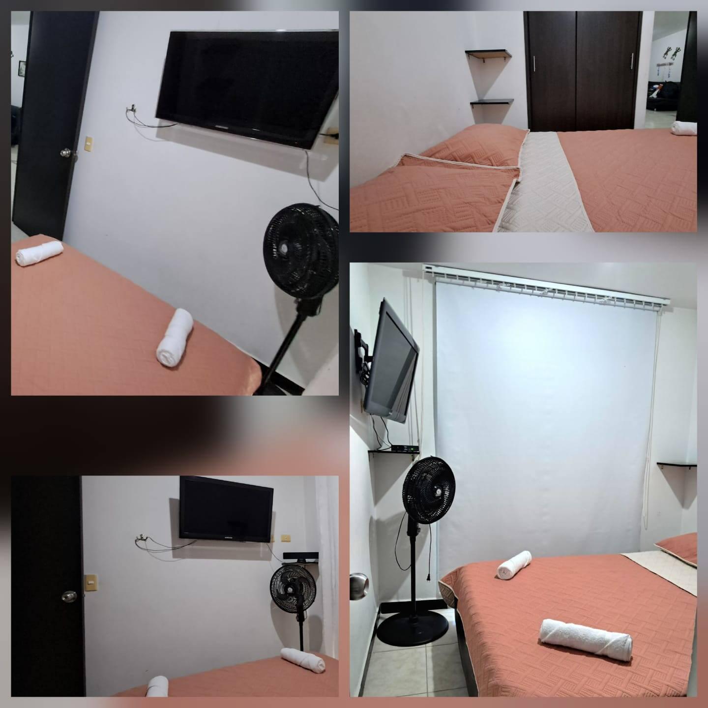 Habitación cómoda con cama doble, TV pantalla plana y ventilador en apartamento Montenegro