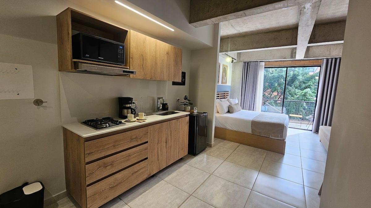 Loft moderno con cocina integral y habitación con balcón en apartamento de Medellín