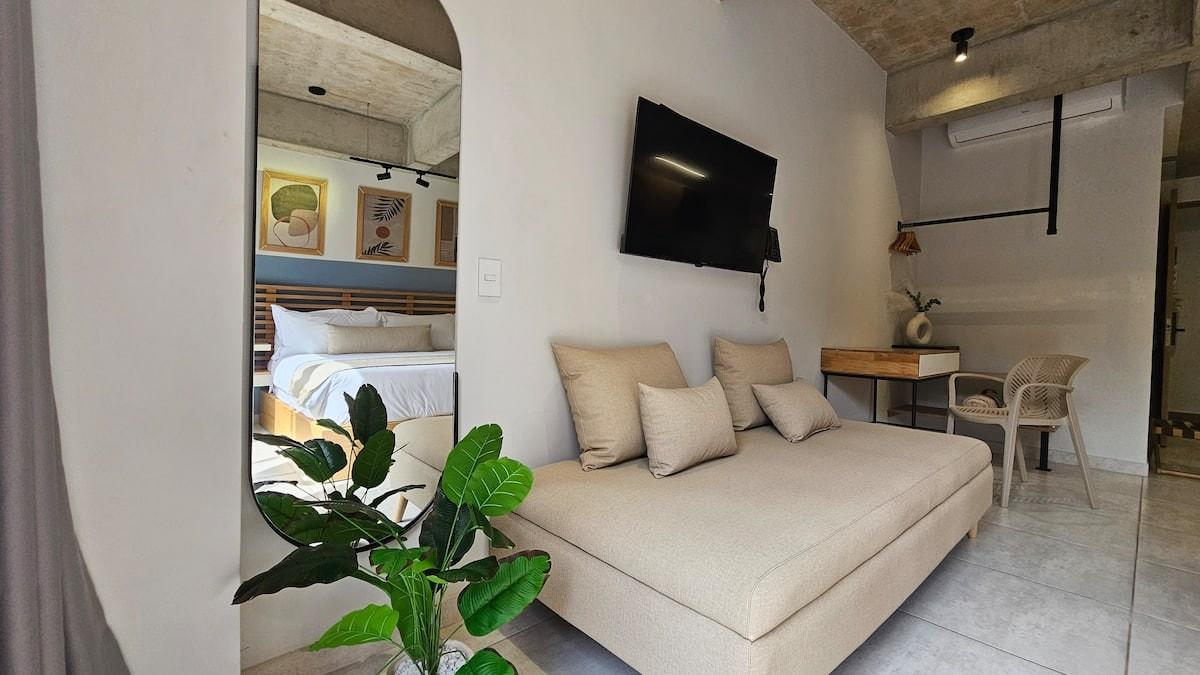 Sala de estar moderna en loft con sofá beige y TV en Medellín apartamento
