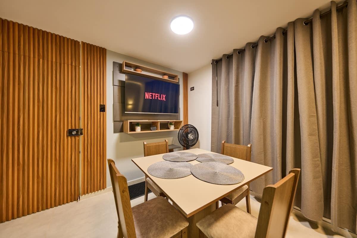 Comedor moderno con mesa de madera y televisión en apartamento Mi segunda morada en Cúcuta