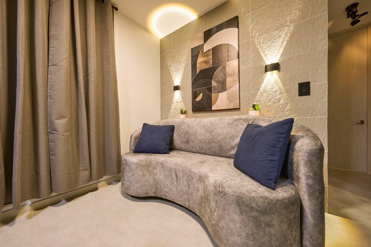 Sala moderna con sofa gris y cojines azules en apartamento Mi segunda morada Cucuta