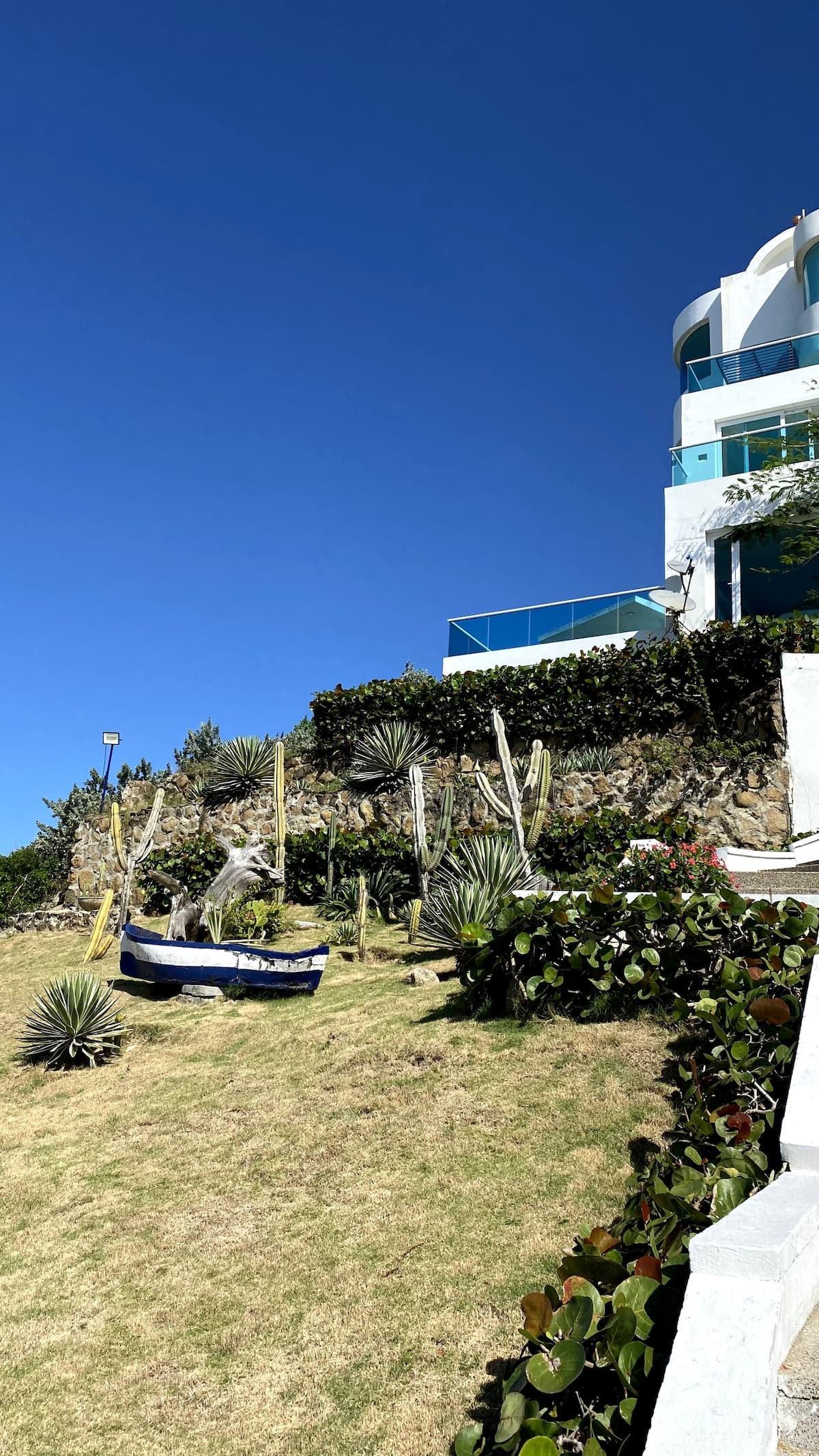 Jardín con cactus y barco decorativo en casa de playa D Hozt Punta Cangrejo en Juan de Acosta