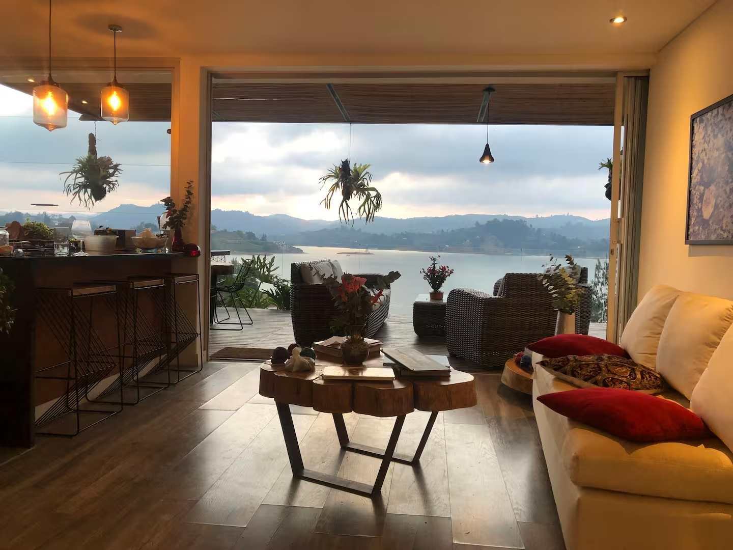Sala de estar moderna con vista panorámica al lago de Guatapé desde villa de lujo en Peñol