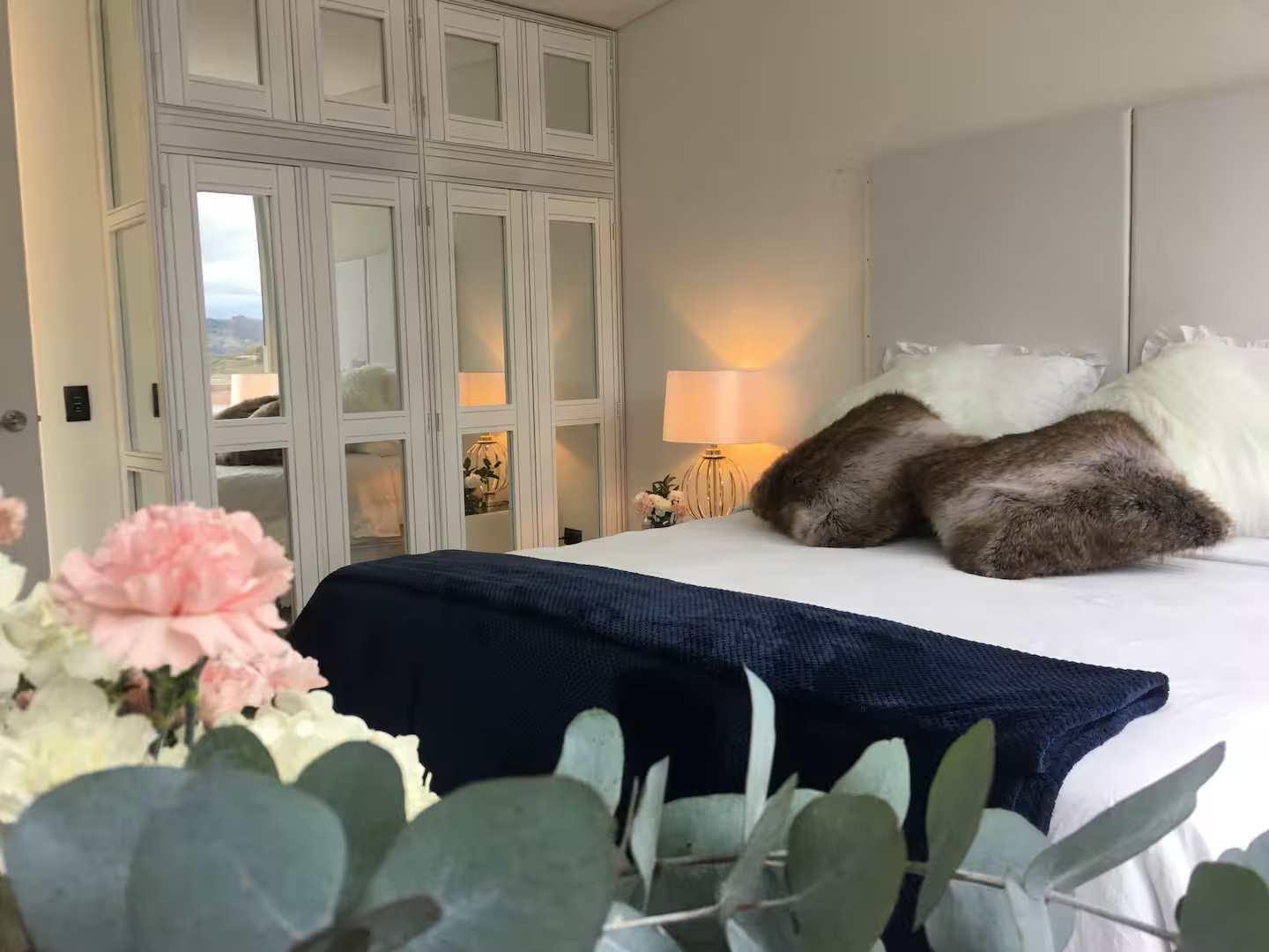 Habitación principal elegante con cama king size y closet espejado en villa de lujo Guatapé Peñol