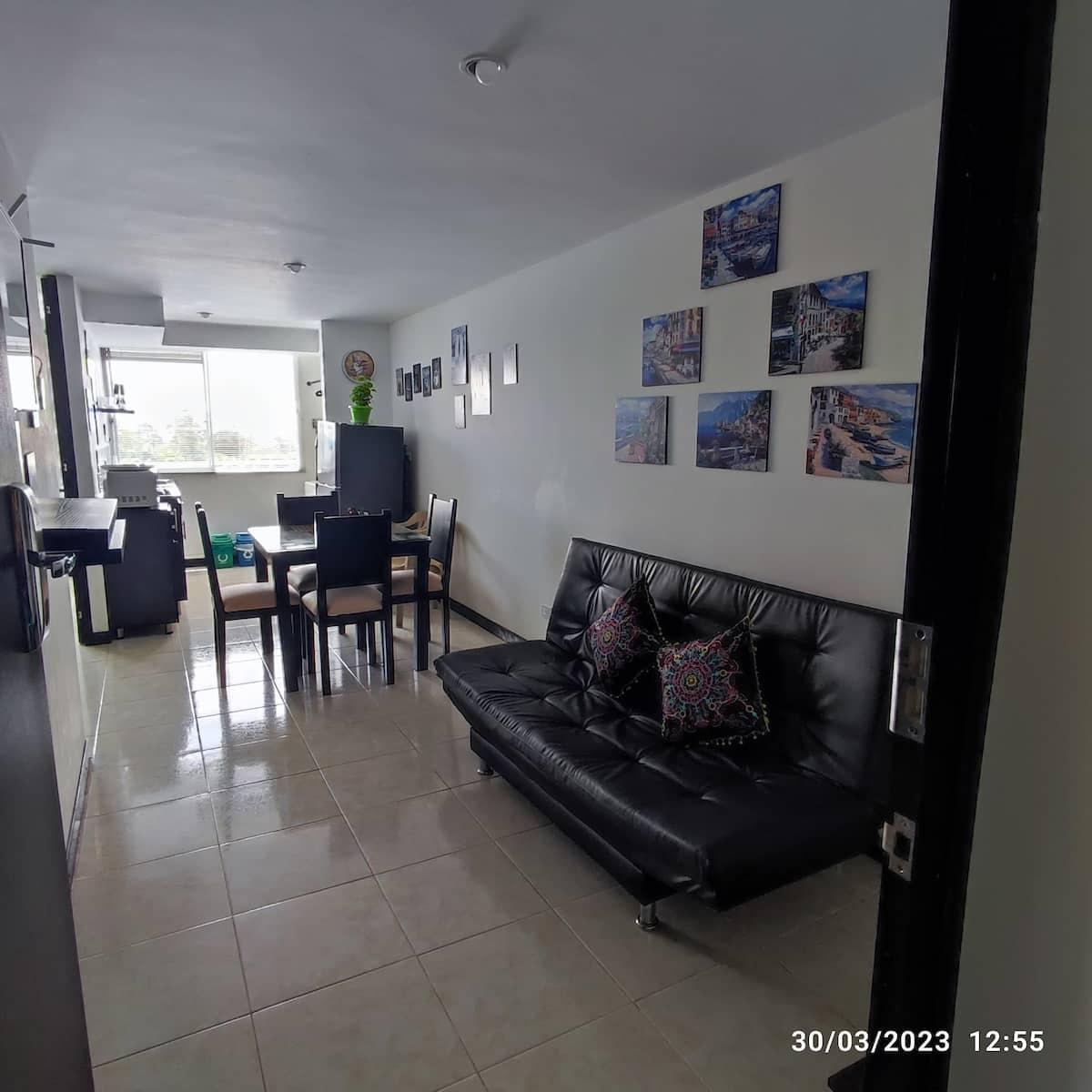 Sala y comedor moderno con sofá negro y decoración en casa vacacional Montenegro Quindío