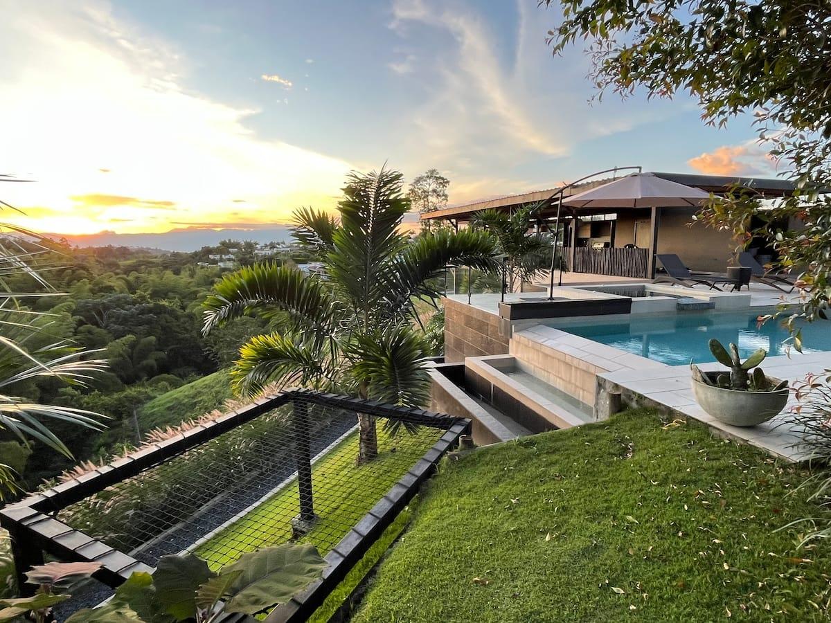 Villa con piscina y terraza panorámica al atardecer en Montenegro, Quindío, rodeada de vegetación tropical