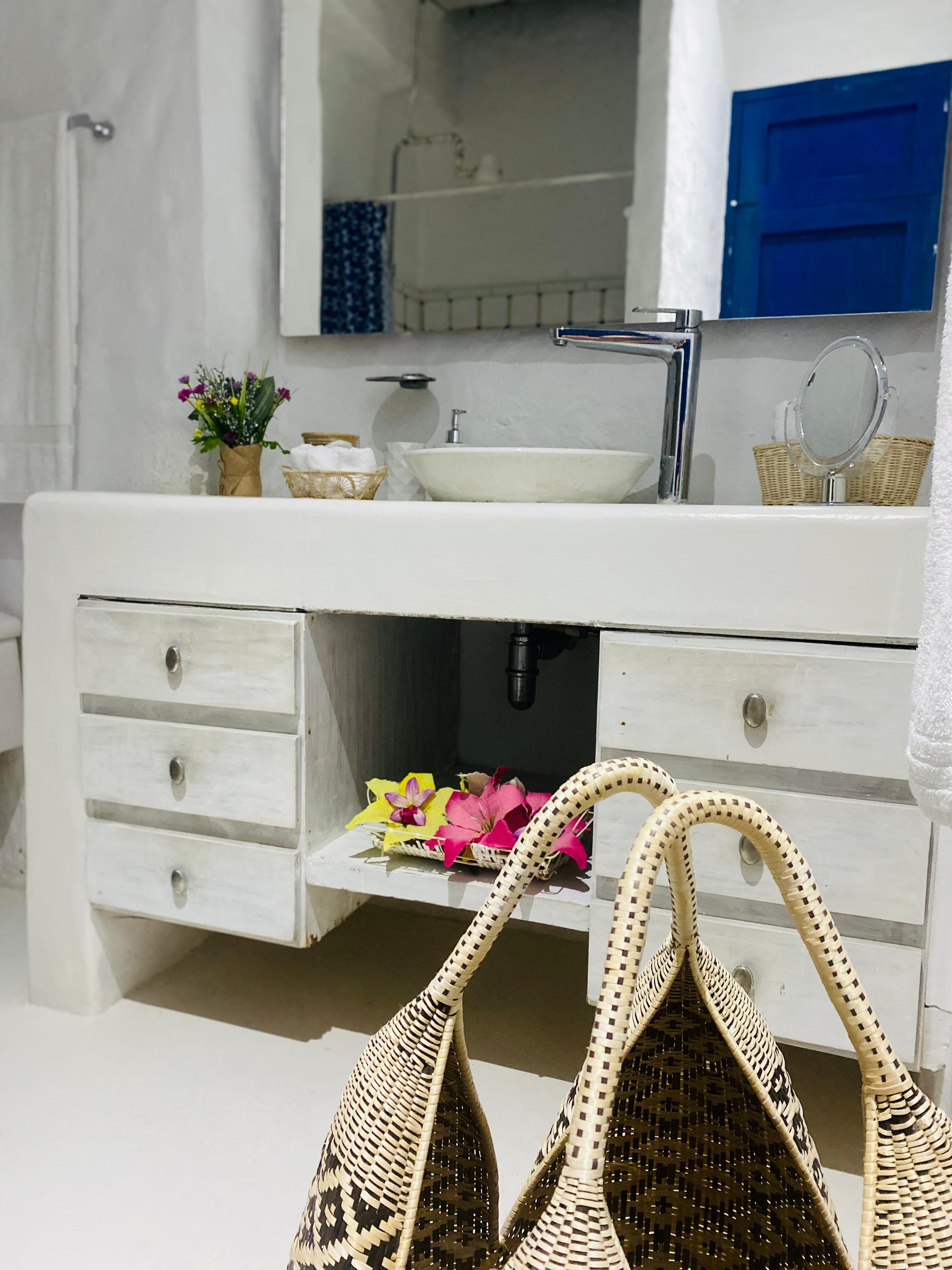 Baño moderno con tocador blanco y espejo en casa privada de Cartagena de Indias