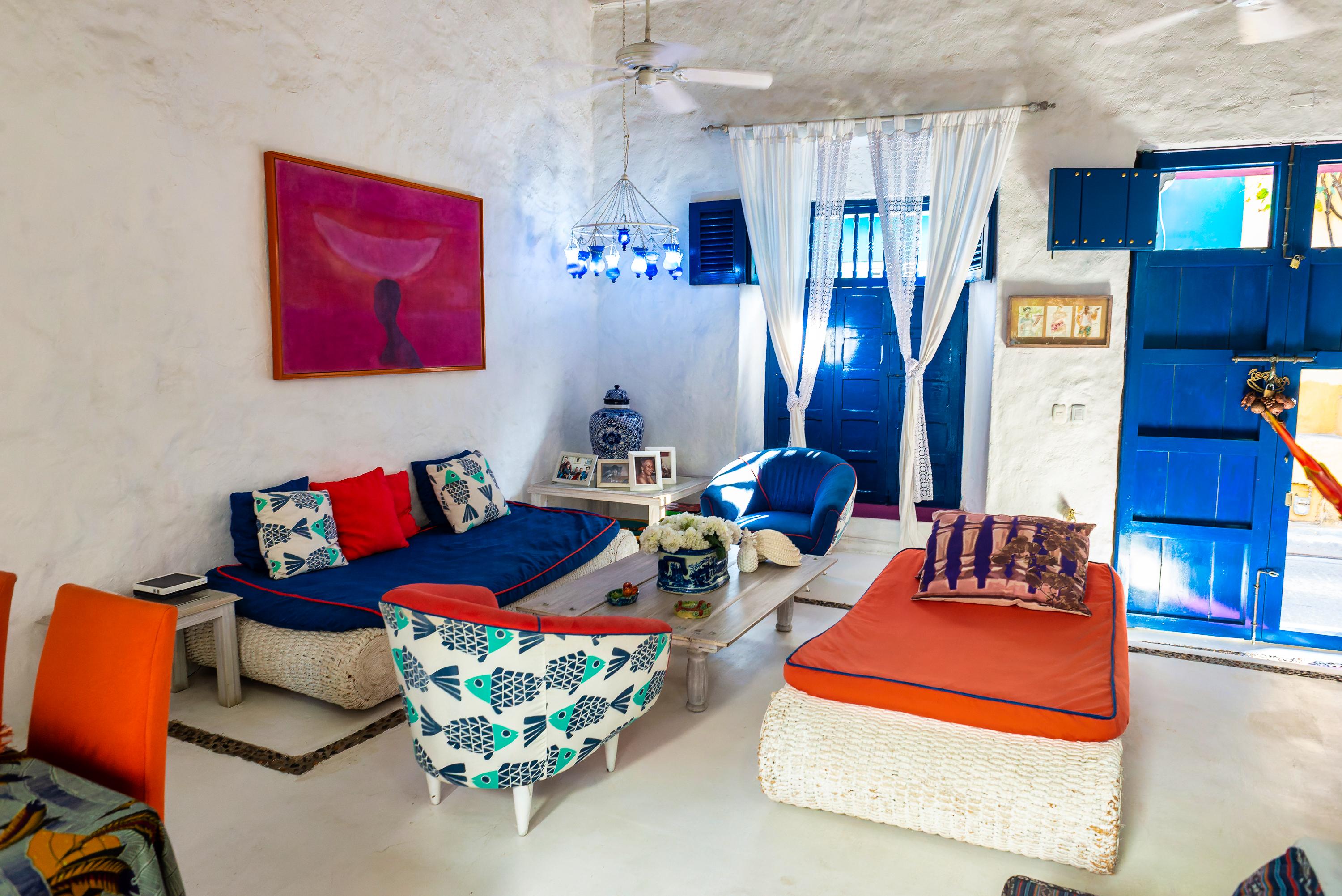 Sala de estar colorida con sofás azules y naranjas en casa privada de Cartagena de Indias
