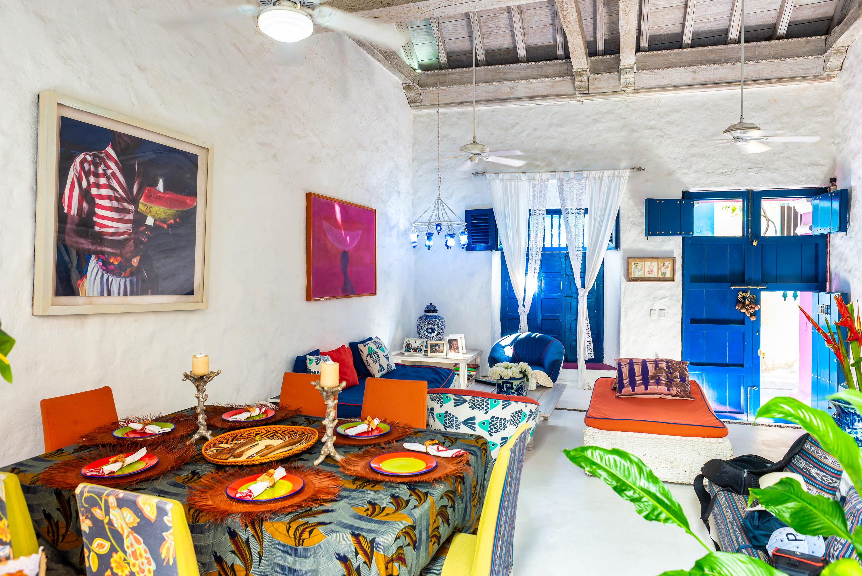Comedor vibrante con mesa decorada y sala de estar en casa privada de Cartagena de Indias