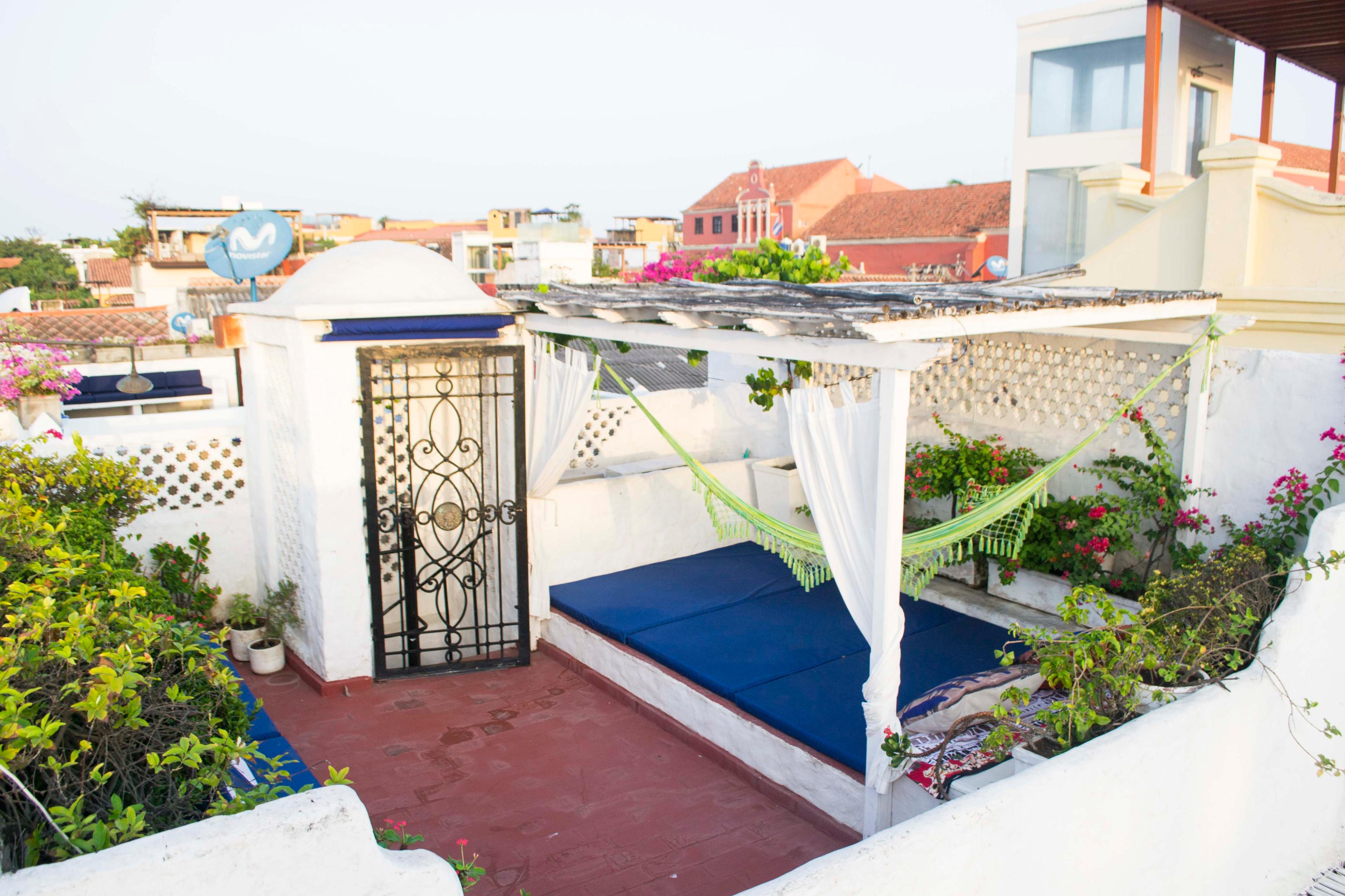 Terraza privada con hamaca y cojines azules en casa de Cartagena de Indias