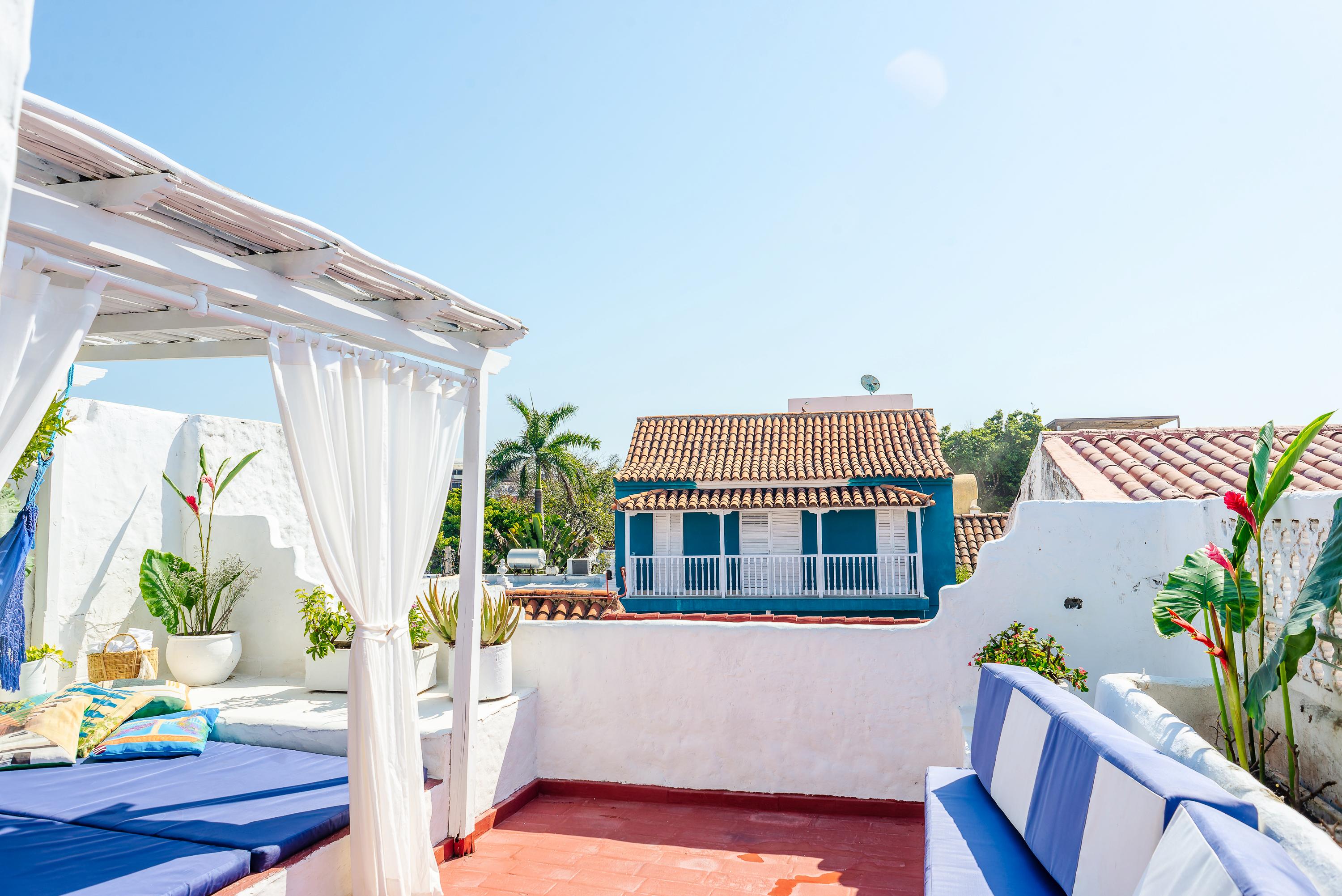 Terraza privada con cama balinesa y vista a techos coloniales en casa de Cartagena de Indias