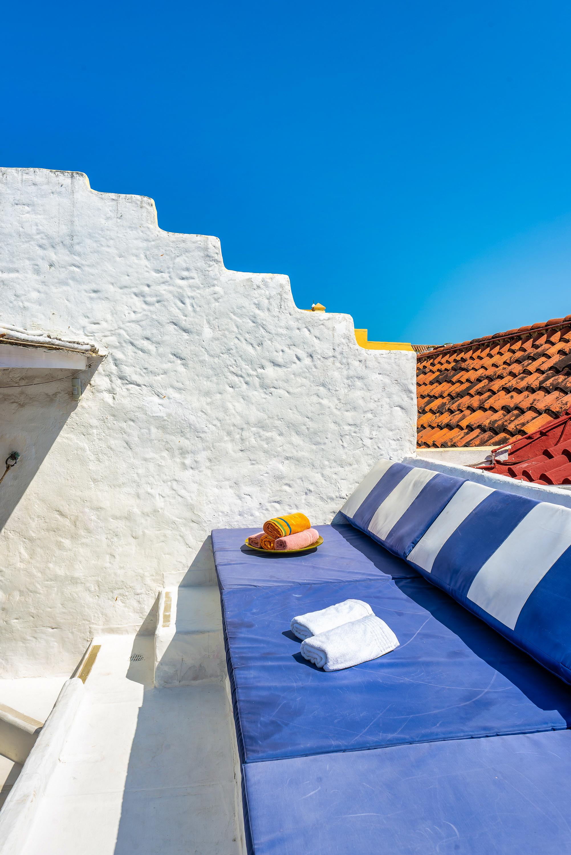 Terraza privada con sofá azul y blanco en casa colonial de Cartagena de Indias