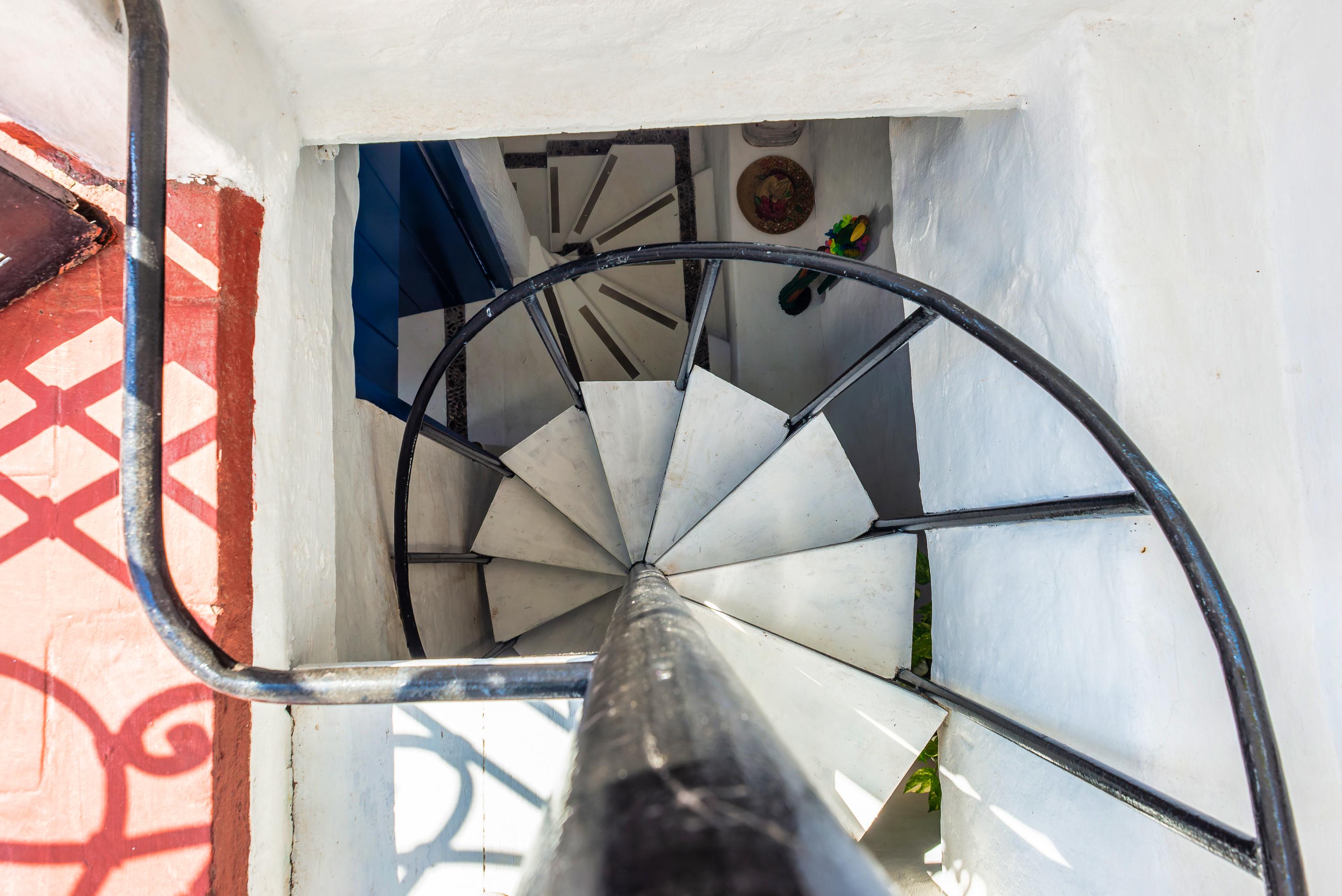 Escalera de caracol con barandas metálicas en casa privada colonial de Cartagena de Indias