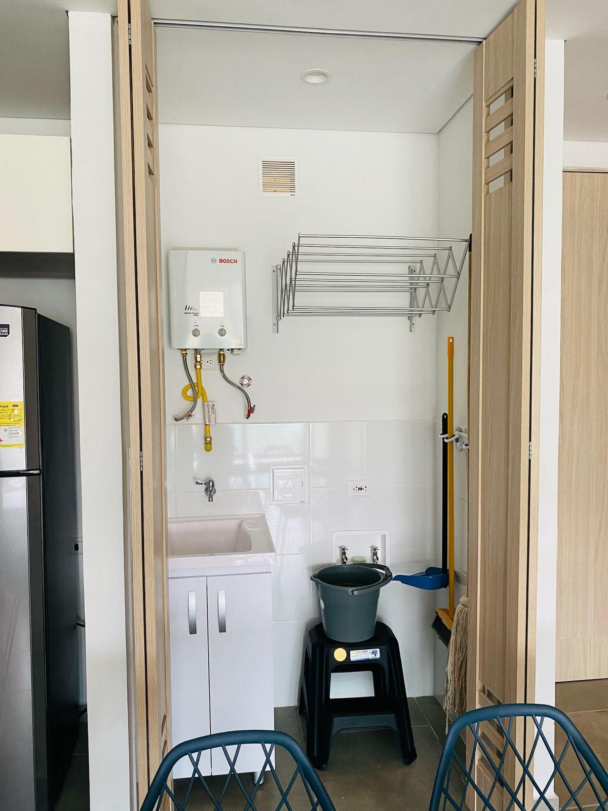 Zona de lavandería completa con calentador Bosch y tendedero en apartamento Santa Marta