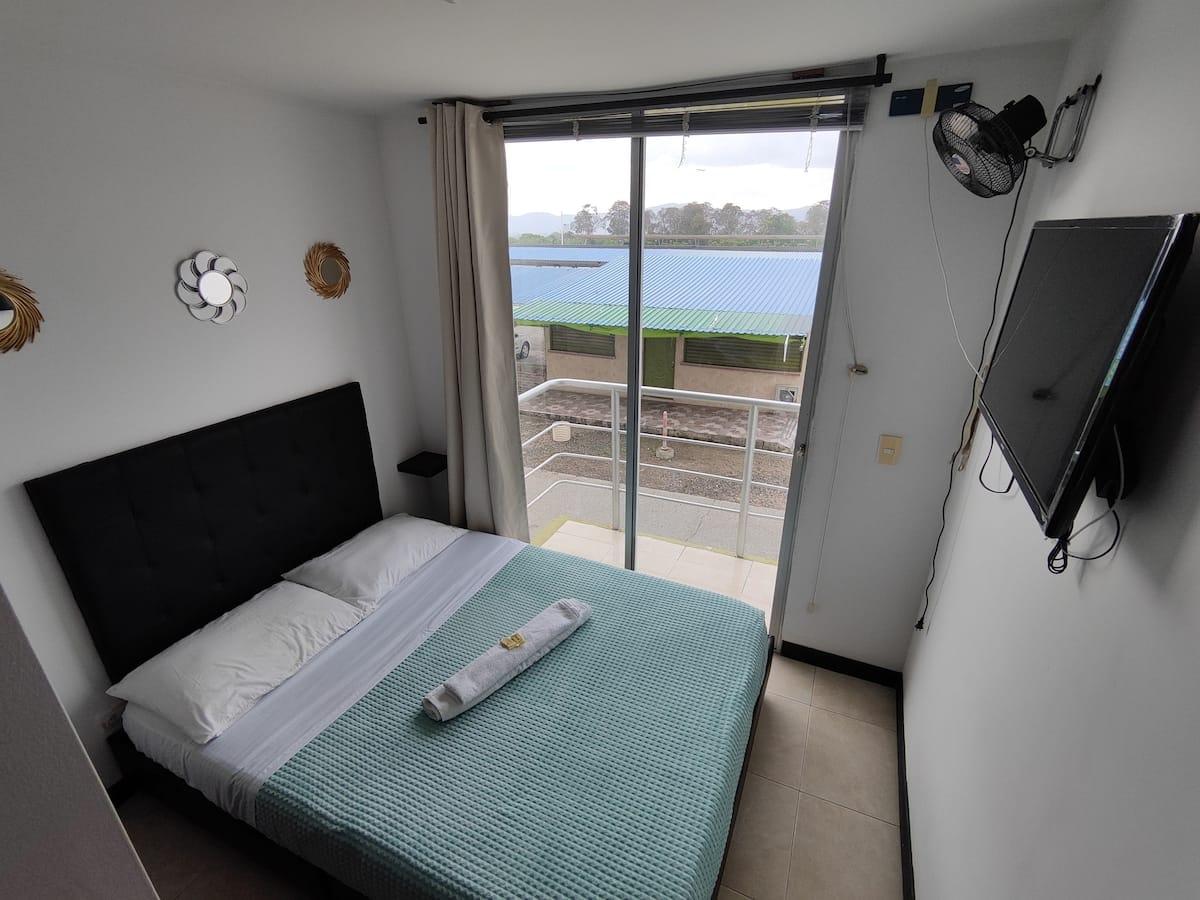 Habitación moderna con cama doble, balcón y vista panorámica en apartamento vacacional Montenegro