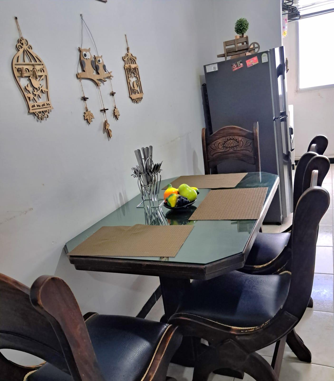 Comedor moderno con mesa de vidrio y sillas negras en apartamento Montenegro cerca Parque del Café